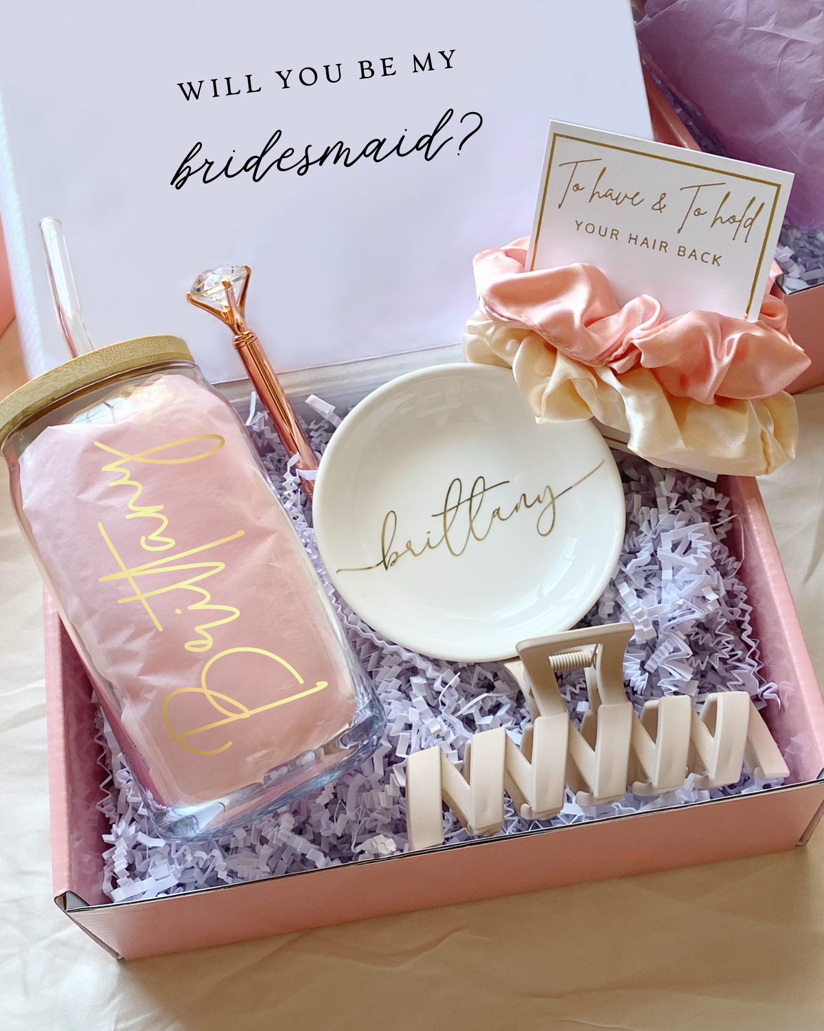 Personalized blush pink bridesmaid gift set with customizable role titles – maid of honor, matron of honor, or your own message. Includes glass tumbler, jewelry dish, scrunchie, hair claw clip, and diamond pen.